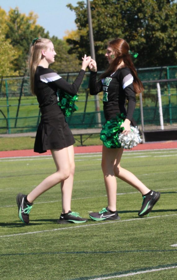 Just before performing with varsity pom at the pep rally, Juniors Megan Kurkowski and Ashley Kakish share a handshake. Kurkowski said they have been doing the same handshake before they perform for two years, symbolizing good luck to help get their nerves out. 