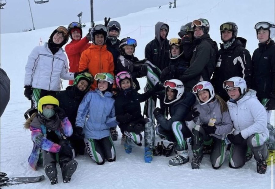 Teammates+from+the+ski+team+all+gather+for+a+picture+on+the+hill.+Behind+the+group%2C+you+can+see+the+ski+lift.