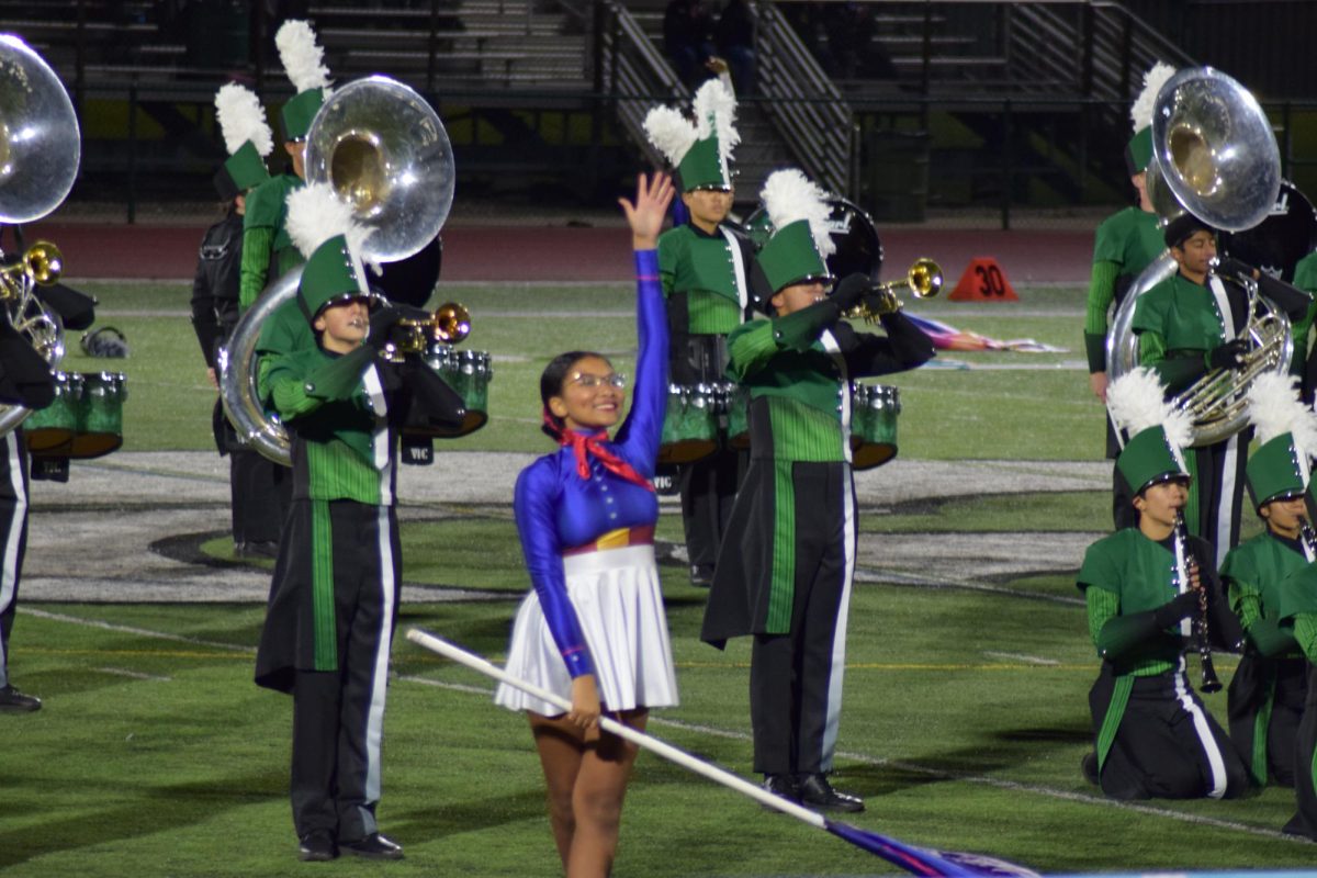 Color guard performer pose in front of marching bands during performance. On Saturday, October 14, Novi High School hosted Fan Fair Marching Band Invitational with 16 schools competing in 4 different categories such as flight l, ll, lll, lV, V. Although Novi did not compete for a reward, members in the marching band enjoyed performing and families from all of the schools got watch as the bands performed throughout the night.