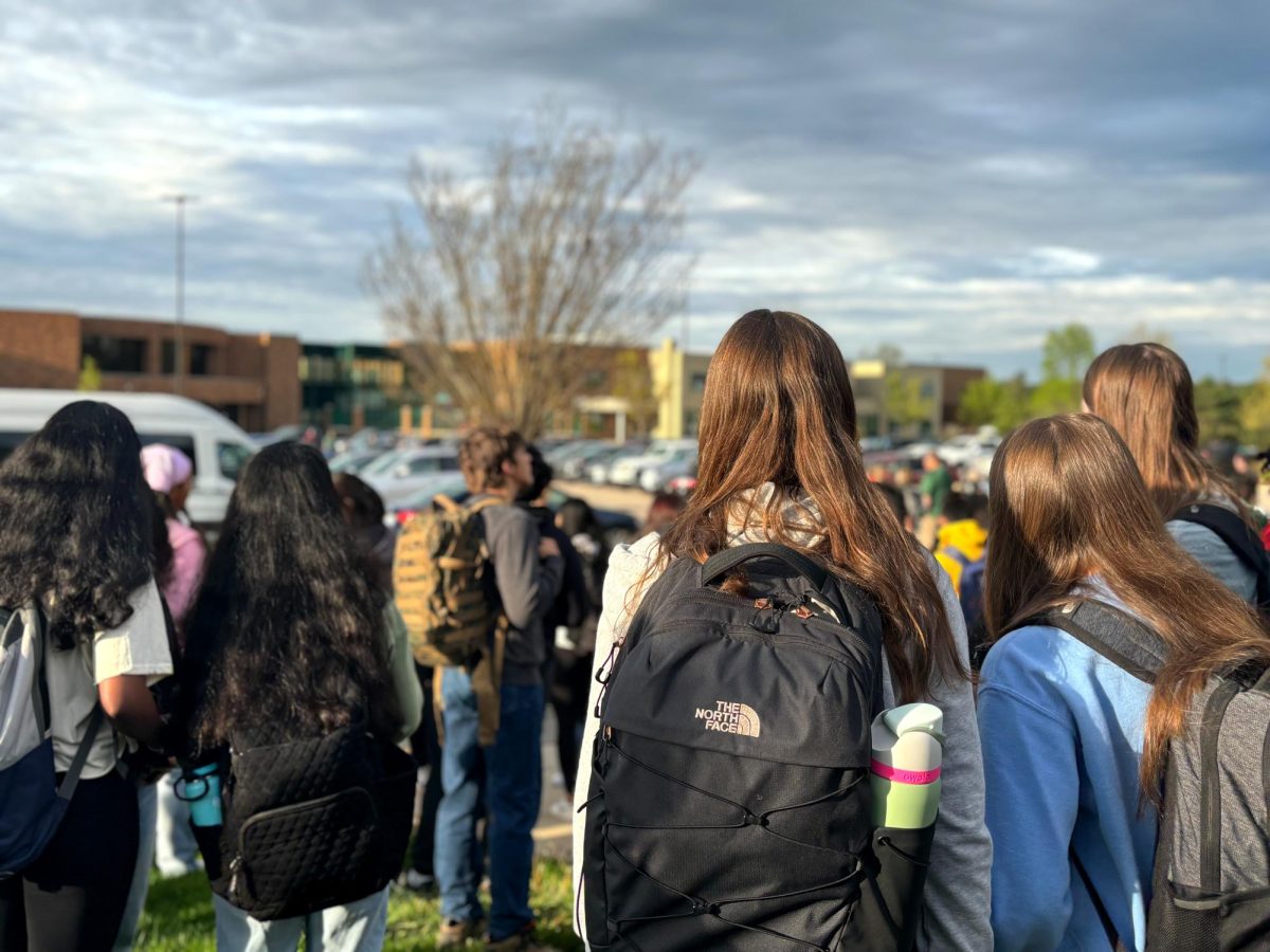 Students gather outside the Novi Public Library after evacuating the high school.